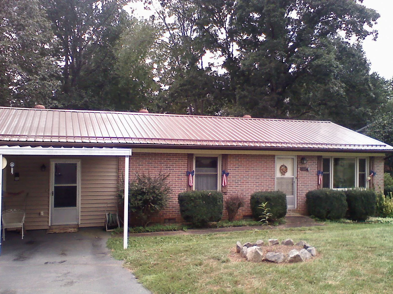 Bronze metal roof and carport on a brick ranch home — Roof Repair work by our crew in Newton Grove